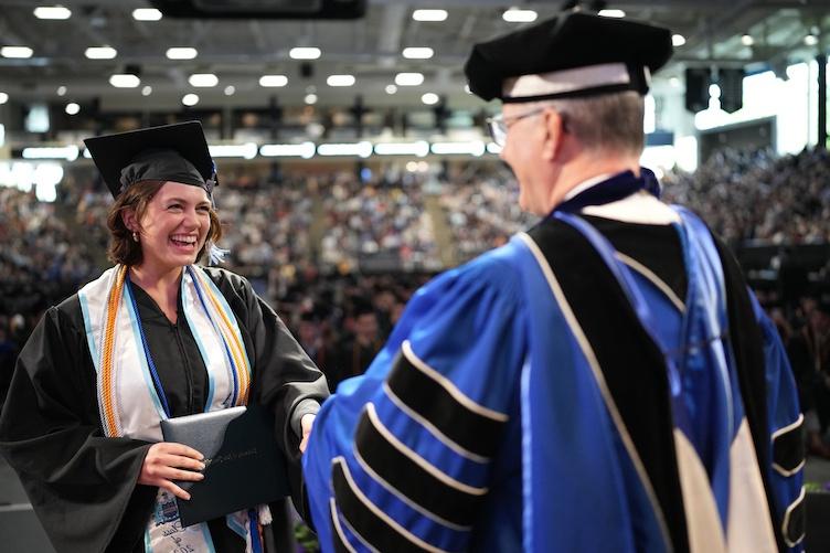 Student shakes president's hand while receiving diploma